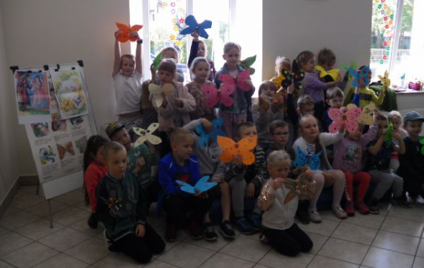 Grupowe zdjęcie przedszkolaków trzymających wykonane przez siebie prace plastyczne