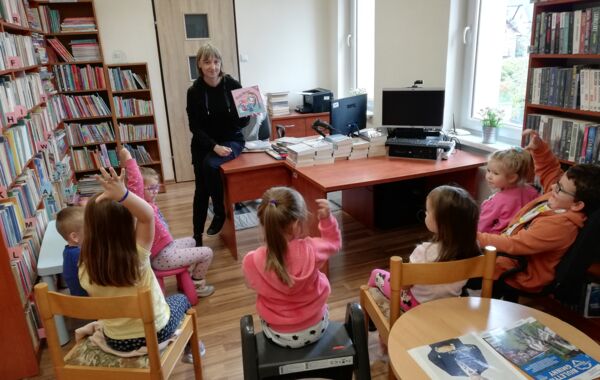 Bibliotekarka pokazująca przedszkolakom książkę