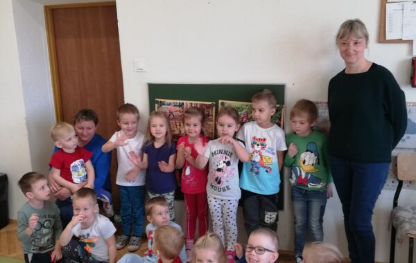 Bibliotekarz oraz dzieci biorące udział w lekcji bibliotecznej