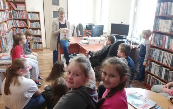 Bibliotekarz pokazuje książkę grupie dzieci