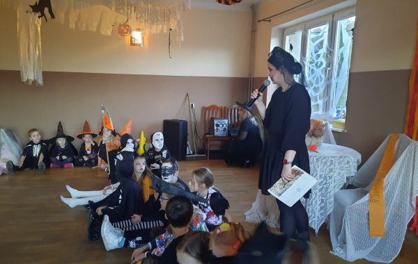 Uczestnicy spotkania podczas słuchania czytanej przez bibliotekarza książki