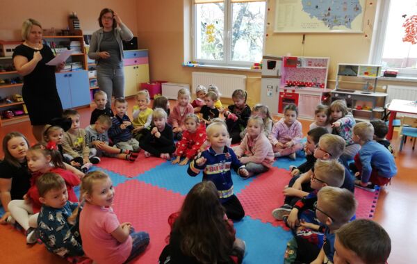 2 grupy przedszkolaków siedzące w swojej salce w oczekiwaniu na bibliotekarkę