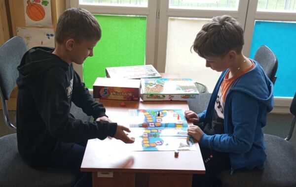 2 chłopców podczas gry w planszówkę