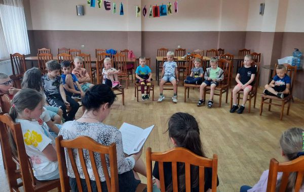 Bibliotekarz podczas czytania książki grupie dzieci