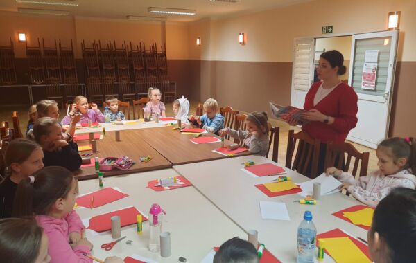 Bibliotekarz czytający wiersze. Dzieci podczas robienia godeł z papieru