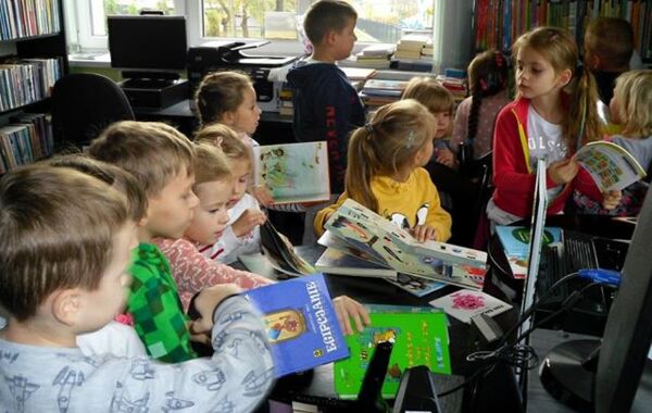 Uczestnicy spotkania oglądają przygotowane książki dla małych czytelników