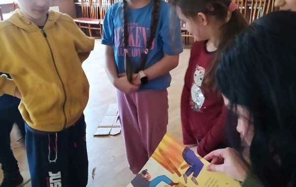 Bibliotekarka czytająca dzieciom książkę "Basia i narty"