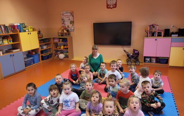 Bibliotekarka oraz dzieci pozujace do zdjęcia