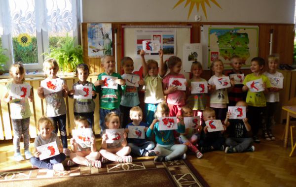 Dzieci trzymające w rękach swoje rysunki