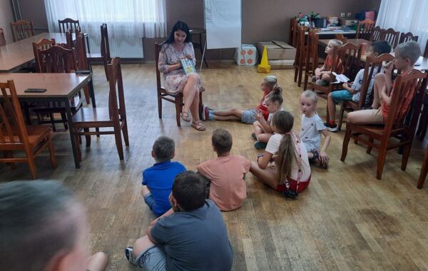 Bibliotekarz podczas czytania książki grupie dzieci