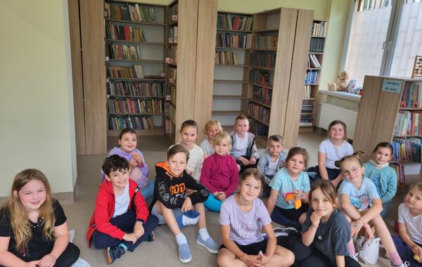 Uczestnicy lekcji bibliotecznej siedzący na podłodze