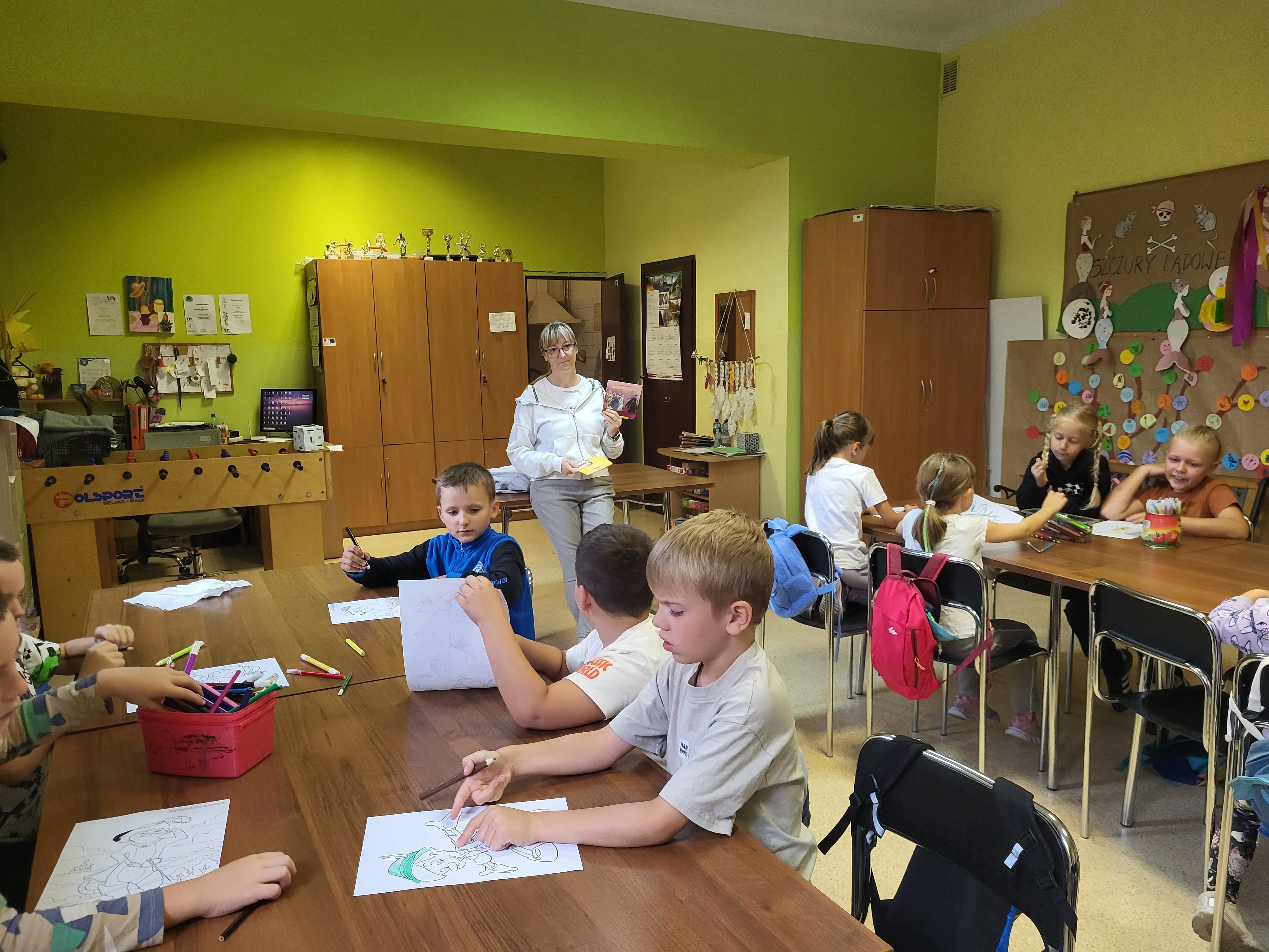 Bibliotekarka oraz dzieci biorące udział w zajęciach